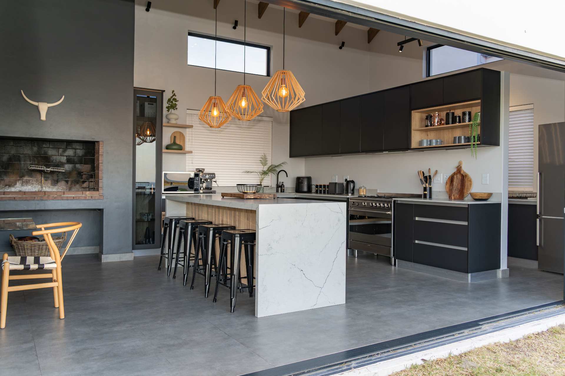 Modern black kitchen with stone island and indoor braai