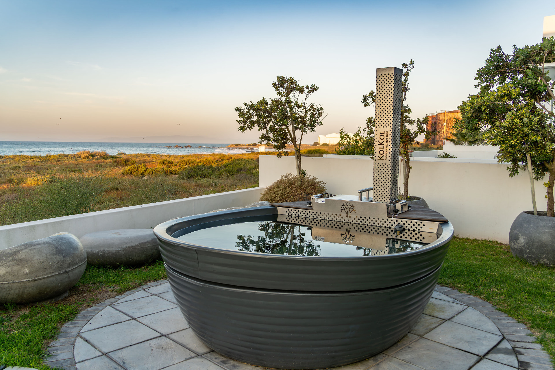 Wood-fired Kol Kol hot tub overlooking the ocean at Starfish Beach Villa
