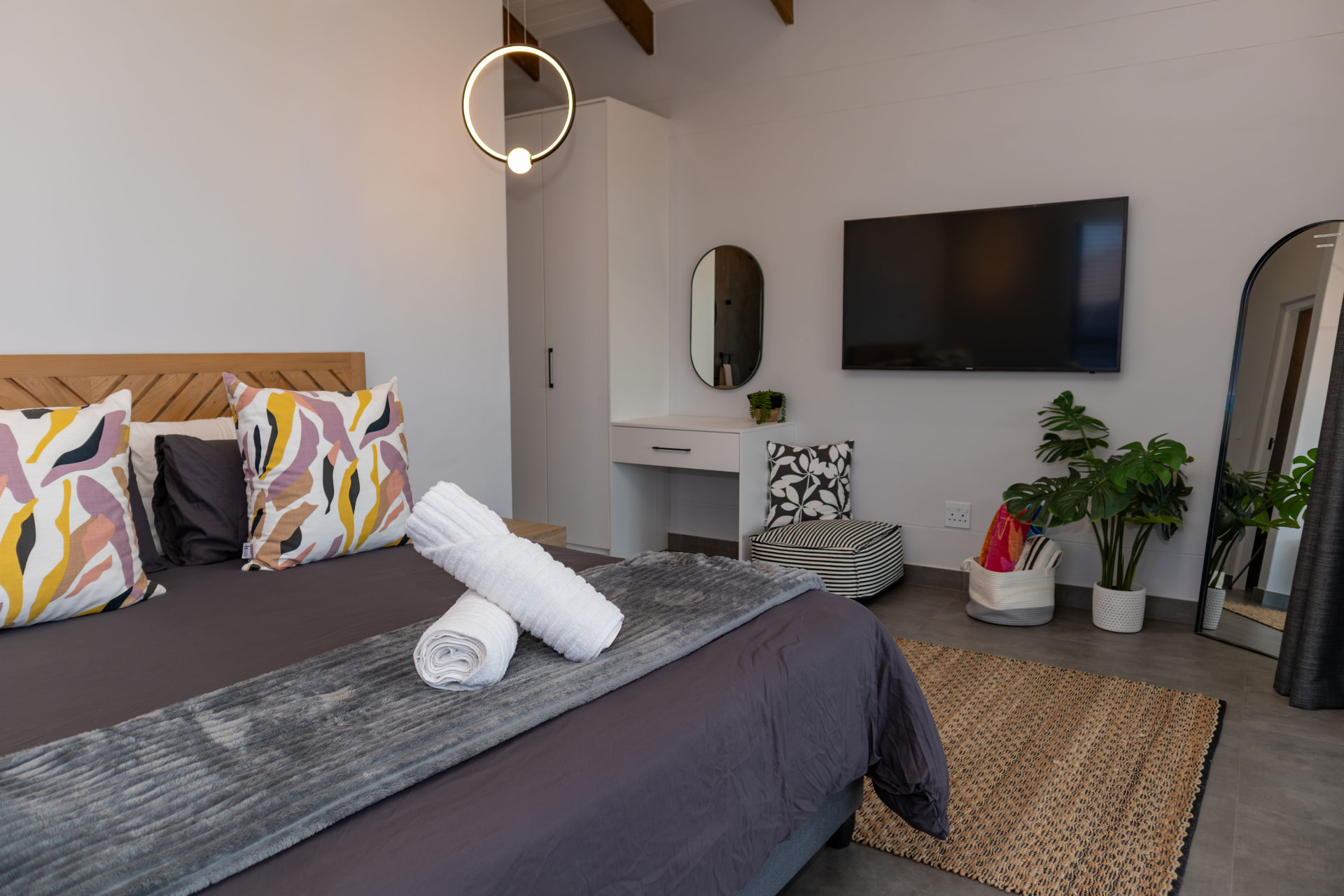 Main bedroom with timber headboard and smart TV